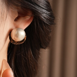Macro view of velvet leopard print hoop earring with pearl detail on model's ear