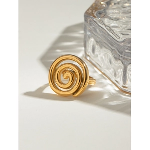 Macro shot of 18k gold stainless steel ring with twisted screw texture on white surface