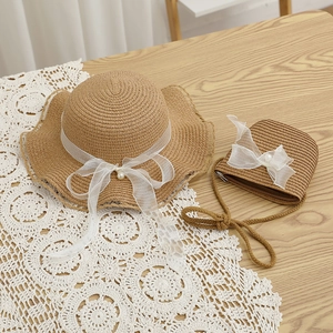 Detail of child straw hat and matching bag set with lace bows and pearl accents