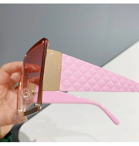 Close-up of pink quilted temples and gold metal frame on square fashion sunglasses