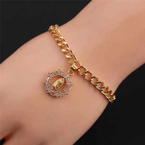 Dettaglio di un bracciale a catena dorata con ciondolo della Vergine Maria in zirconi