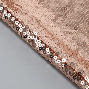 Detailed macro view of sparkling rose gold sequins and mesh fabric on a two-piece set