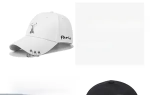 Close-up of white cotton baseball cap featuring Paris embroidery and metal ring charms