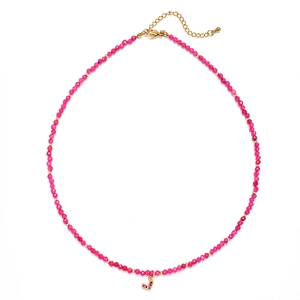 Macro view of rose red faceted beads with heart pendant and golden lobster clasp