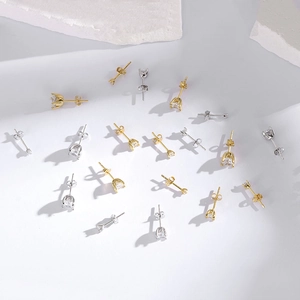 Flat lay of multiple S925 sterling silver mini stud earrings with four-prong cubic zirconia