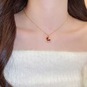 Close-up of gold-plated pony necklace with red enamel and zircon accents on model