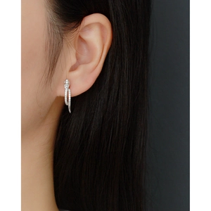 Close-up of a silver snake-shaped earring with micro-pave diamonds on a model ear