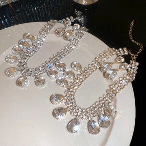 Detail of silver and gold teardrop fringe necklaces with shimmering crystals on a tray