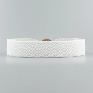 Detail of white elastic waist belt with textured gold round buckle for women