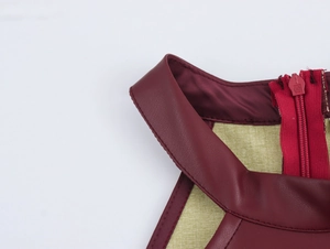 Detail van de bordeauxrode PU-lederen kraag en groene textielstof met verborgen rits