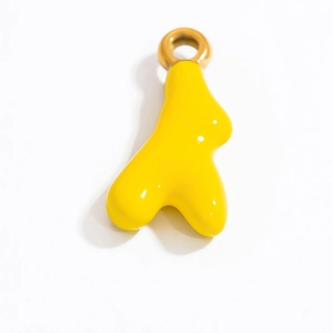 Dettaglio macro di un ciondolo a cuore fluido giallo lucido con anello dorato DIY