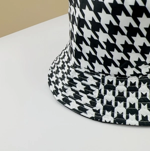 Detailed view of black and white houndstooth bucket hat with fine stitching and cotton texture
