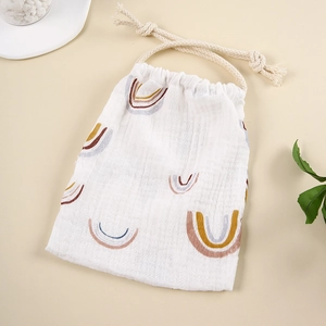 Detail of soft muslin cotton drawstring bag with rainbow prints for baby accessories
