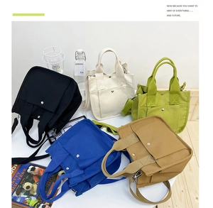 Detailed view of canvas tote bags in five colors with adjustable straps and metal buttons