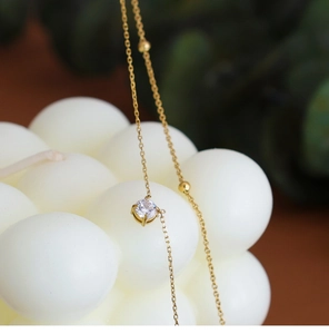 Macro view of 18K gold plated stainless steel necklace with zircon pendant and gold beads