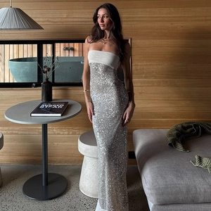 Close-up of sparkling silver sequins and white strapless bodice on a slim maxi dress