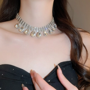 Close-up of model wearing a layered silver rhinestone necklace with teardrop crystals