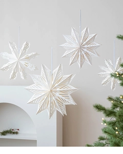 Close-up of 3D white paper snowflake stars with intricate laser-cut hollow patterns