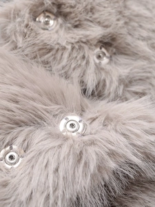 Close-up of grey faux fur fabric texture featuring a polished silver metal snap button