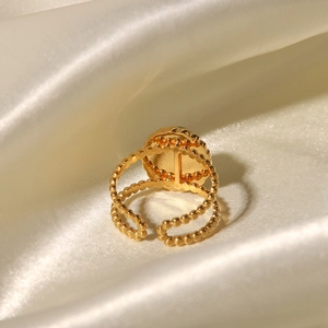 Detail of vintage gold ring with green natural stone on elegant beige satin fabric