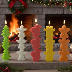 Stacked Christmas candles featuring tree, angel, and deer shapes on a festive mantel