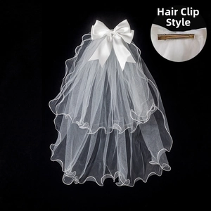 Detail of white bridal veil with large satin bow and metal spring clip for hair