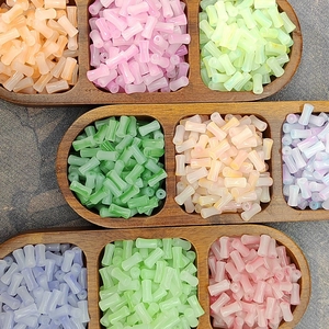 Colorful 6x12mm gradient glass bamboo beads in a wooden tray for DIY jewelry making