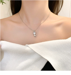Close-up of minimalist silver kitten necklace with a sparkling round zircon stone