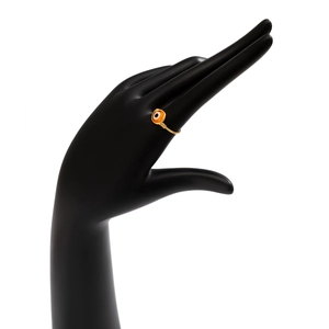 Handcrafted gold wire-wrapped evil eye ring with orange bead on a black hand model