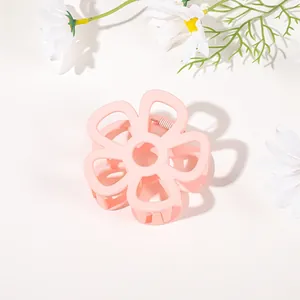 Detailed view of pink flower hair claw clip with matte finish on white background