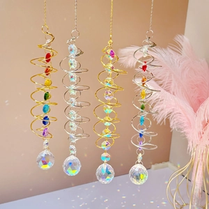 Close-up of gold and silver spiral suncatchers reflecting rainbows with crystal balls