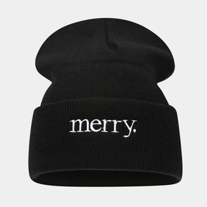 Detailed view of white 'merry.' embroidery on black knitted beanie with premium texture