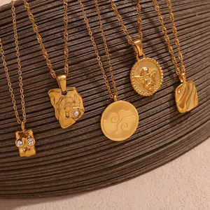 Macro shot of gold plated pendant necklaces featuring angel relief and pavé zircons