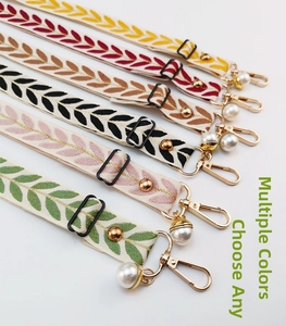 Detail of floral embroidery phone straps in various colors with gold metal hooks and pearls