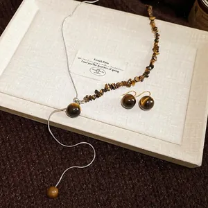 Tiger eye stone necklace and earrings jewelry set on a white elegant display tray