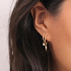 Close-up of gold hoop earrings featuring sparkling star and lightning bolt zircon charms