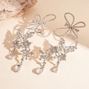 Elegant silver butterfly flower ear cuff with sparkling teardrop crystals on wood