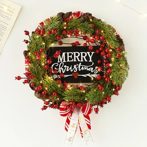 Christmas wreath with LED lights, red berries, pine needles and Merry Christmas sign