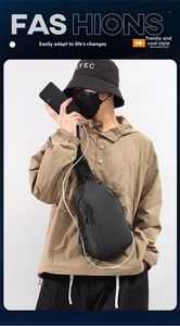 Detail of black waterproof chest bag for men showing integrated USB charging port with phone