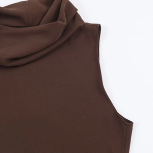 Detail of chocolate brown sleeveless top featuring a mock neck and textured woven fabric