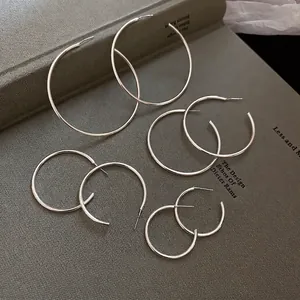 Set of four polished silver geometric hoop earrings in various sizes for women