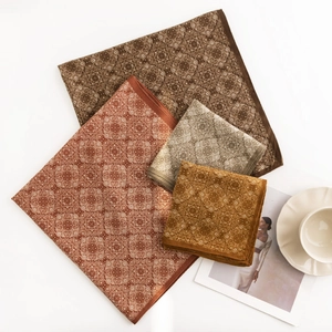 Set of four vintage houndstooth silk scarves in warm autumn tones on a white surface