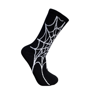 Détail de chaussette mi-haute noire avec motif toile d'araignée blanche sur fond blanc