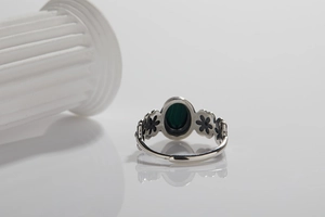 Close-up of vintage S925 silver ring with green oval malachite and flower carvings