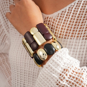 Close-up of chunky geometric resin bracelet with gold metal bars on female wrist