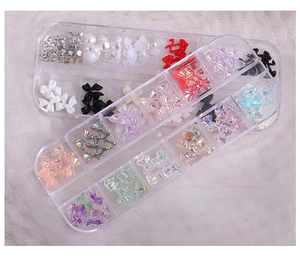 Macro shot of 3D aurora crystal nail charms in a multi-grid storage case set