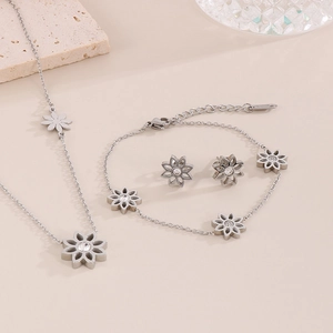 Macro view of silver floral jewelry set with clear crystals on stones and glass background
