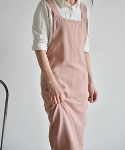 Detailed view of pink linen apron with square neck and large functional front pockets