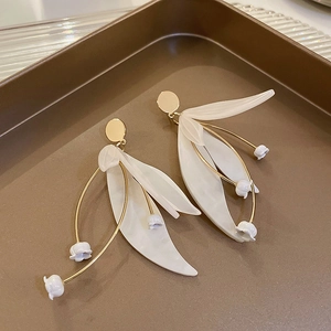 Detailsicht der Maiglöckchen-Ohrringe mit weißen Blütenblättern und goldenem Metallstiel