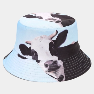 Close-up of light blue cotton bucket hat featuring a realistic black and white cow print